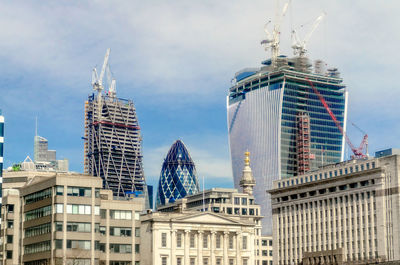 Low angle view of buildings against cloudy sky