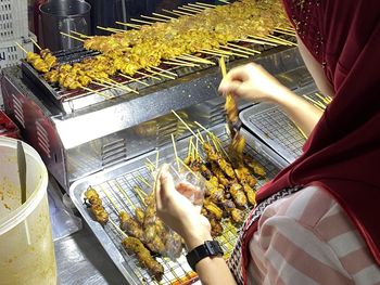 Low angle view of person preparing food on barbecue grill