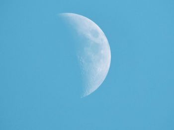 Low angle view of moon against clear blue sky