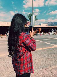 Rear view of woman standing on street against sky and arabesque city