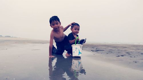 Friends on beach against sky