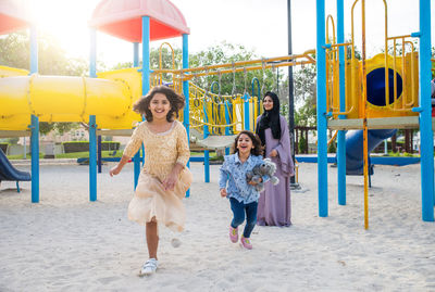 Mother with cheerful daughters enjoying at park