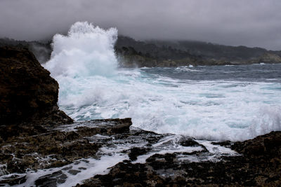 Scenic view of rocks in sea against sky