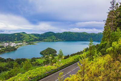 Scenic view of road by trees against sky