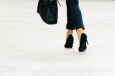 Low section of woman walking on footpath