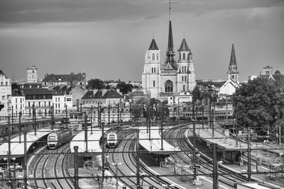 Railroad tracks in city against sky