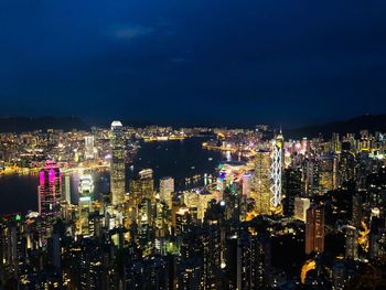 Illuminated cityscape against sky at night