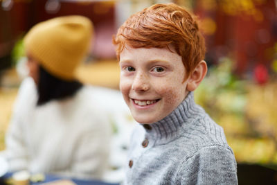 Portrait of smiling boy sitting at yard