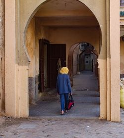 Full length rear view of woman walking in building