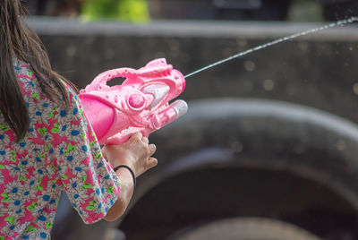 Close-up of woman holding pink rose