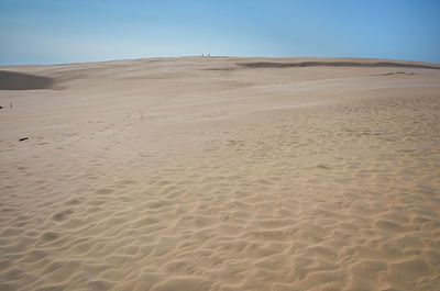 Sand dunes in desert against clear sky