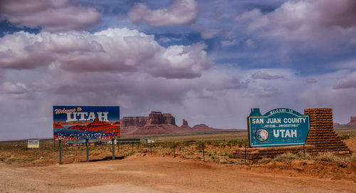 Information sign against cloudy sky