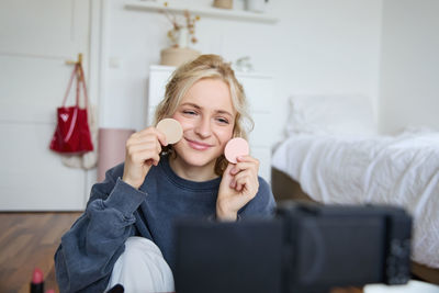 Portrait of smiling young woman drinking milk at home