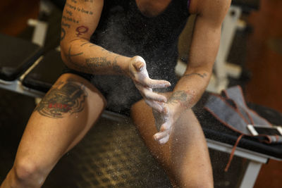 Woman applying chalk powder on hands