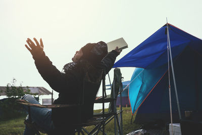 Midsection of man holding umbrella against clear sky