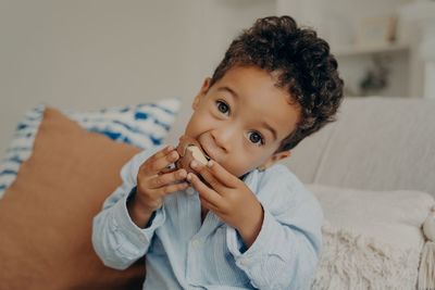 Portrait of cute boy eating chocolate at home