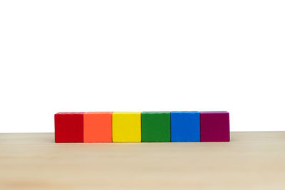 Close-up of multi colored toy blocks on table against white background