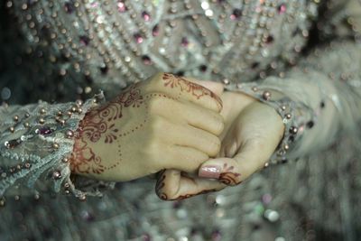 Woman decirated hand with henna at her wedding