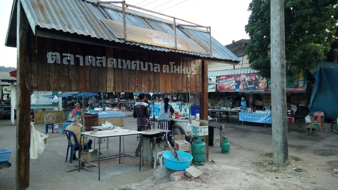 PEOPLE IN MARKET STALL