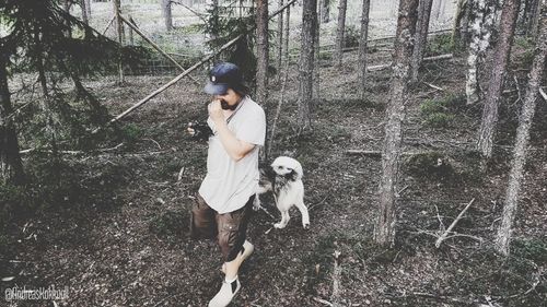 Full length of woman with dog in the forest