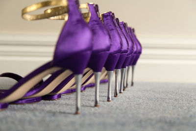Row of purple high heels on carpet