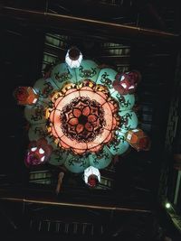 Low angle view of illuminated chandelier hanging on ceiling