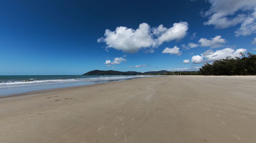 Scenic view of beach against blue sky