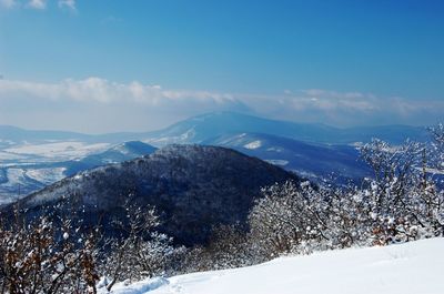 Scenic view of snowcapped mountains against blue sky