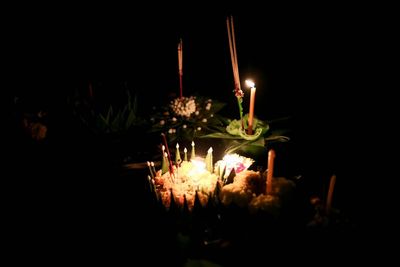 Close-up of lit candles in the dark
