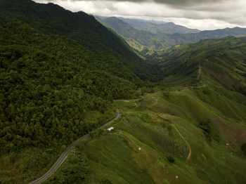 Aerial view of countryside road passing through the lush greenery tropical rain forest mountain