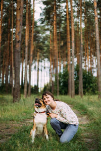 Side view of woman with dog in forest