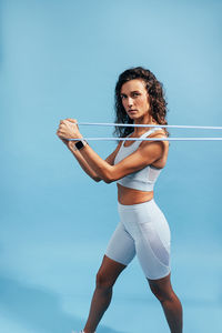 Determined athlete exercising against blue background