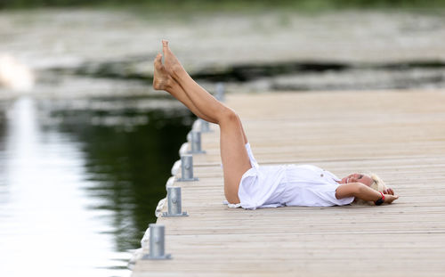 Low section of woman sitting on pier