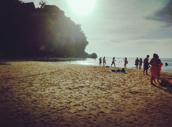 People walking on beach against sky