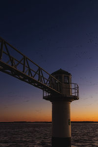Silhouette lighthouse against sky during sunset