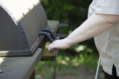 Close-up of woman hand holding metal in yard