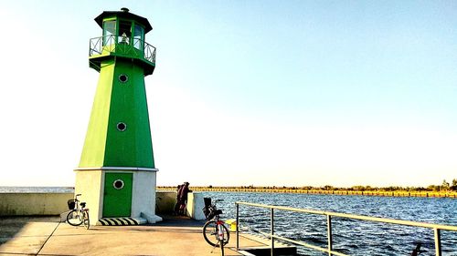 Bicycle by sea against clear sky