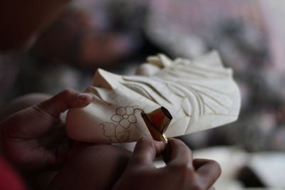 Cropped hands of artist making floral pattern on statue 