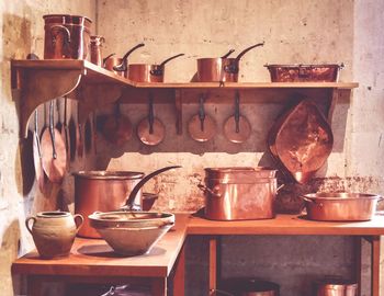 Utensils arranged on shelf in kitchen