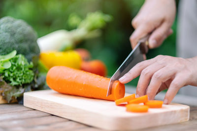 Cropped image of person preparing food on cutting board