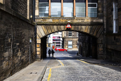 People walking on road amidst buildings in city