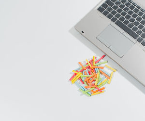 High angle view of multi colored pencils on white background