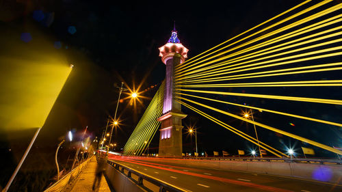 Light trails on bridge in city at night