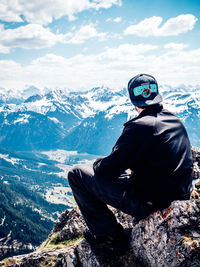 Rear view of person skiing on snow covered mountain