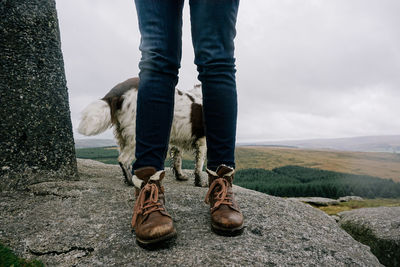 Low section of man standing on landscape against sky