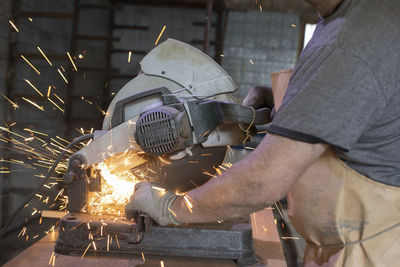 Midsection of man working at workshop