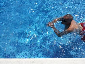 High angle view of shirtless man swimming in pool