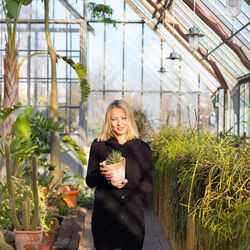 Young woman standing in greenhouse