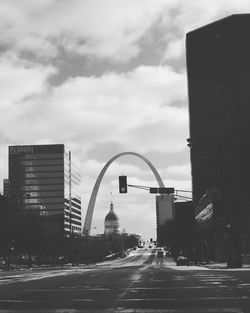 Traffic on road by buildings against sky