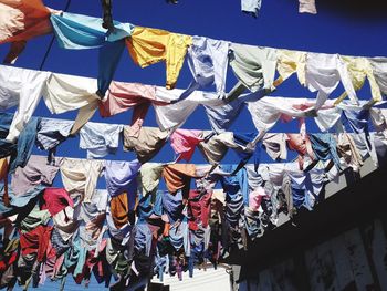 Low angle view of clothes drying on line against sky